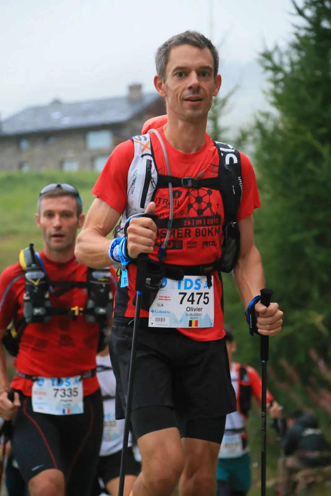 Coureur de trail sur un sentier avec d’autres participants.