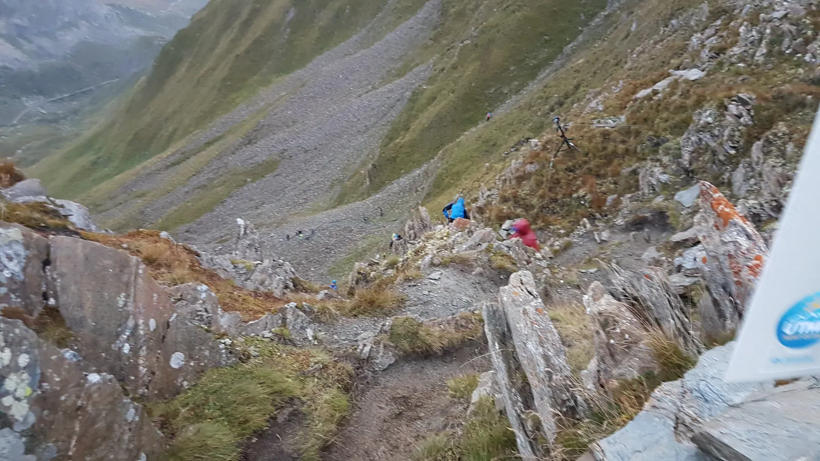 Sentier rocheux serpentant au flanc d’une montagne.